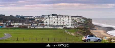 Cromer Beach und clifftop Caravan Park bei Ebbe North Norfolk im Winter Stockfoto