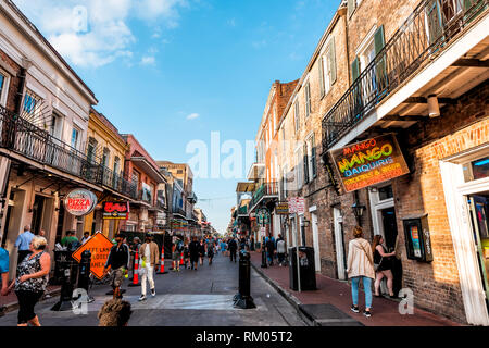 New Orleans, USA - 23. April 2018: Innenstadt Altstadt Bourbon Street in Louisiana berühmten Stadt Stadt Sonnenuntergang am Abend mit Leuchtreklamen und viele Menschen Stockfoto