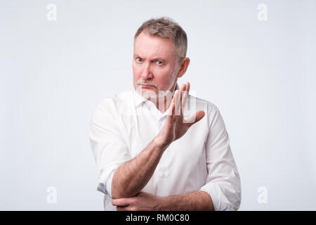 Gut aussehender älterer Mann, STOP-Schild. Negative facial Emotion Stockfoto