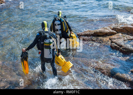 Zwei Taucher in das Meer mit Apollo Av-1 Roller vom Strand, Sant Feliu de Guixols, Katalonien, Spanien Stockfoto