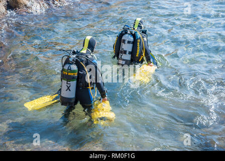 Zwei Taucher in das Meer mit Apollo Av-1 Roller vom Strand, Sant Feliu de Guixols, Katalonien, Spanien Stockfoto