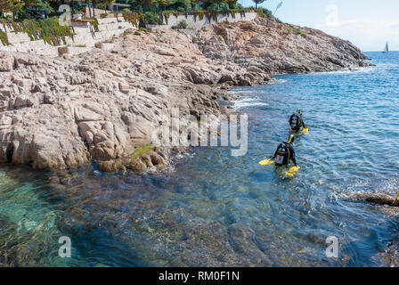 Zwei Taucher in das Meer mit Apollo Av-1 Roller vom Strand, Sant Feliu de Guixols, Katalonien, Spanien Stockfoto