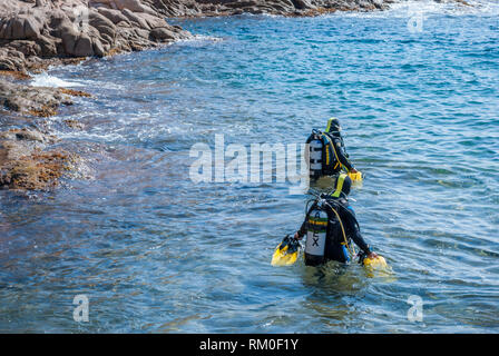 Zwei Taucher in das Meer mit Apollo Av-1 Roller vom Strand, Sant Feliu de Guixols, Katalonien, Spanien Stockfoto