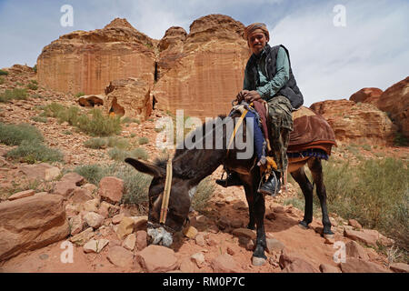 Eine freundliche Beduinen auf einem Maultier zeigt lokale Gastfreundschaft in Petra in Jordanien. Stockfoto