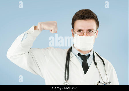 Jungen Kerl Arzt zeigt mit der Hand palm Stop-Schild auf einem blauen Hintergrund isoliert. Konzept Medizin und Gesundheit Stockfoto