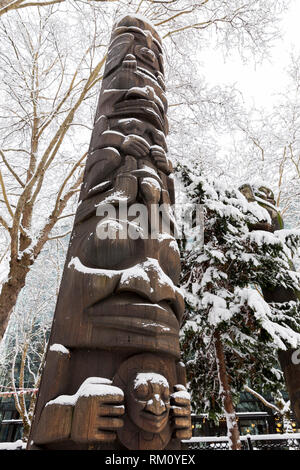 Seattle, Washington: Duane's Pasco Totem der un und Raven' ist mit frischem Schnee in der abendländischen Platz Abgestaubt als starker Wintersturm decken die Stadt. Stockfoto