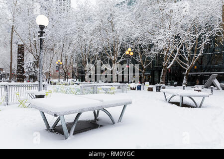 Seattle, Washington: Tischtennisplatten in der abendländischen Square ungenutzte Sitzen als starker Wintersturm decken die Stadt in sechs Zentimeter Schnee. Stockfoto