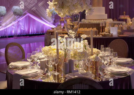 Moody beleuchtetes Ambiente einer Hochzeitsfeier, luxuriöse elegante Tabelle einstellen Stockfoto