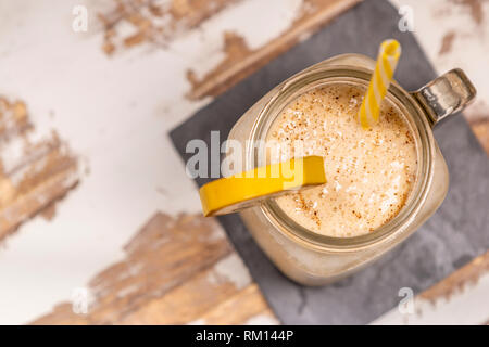 Von oben leckere frische Getränk im Glas Becher mit Kunststoffrohr und Schneiden von Obst auf der Achterbahn auf Holz Tisch Stockfoto