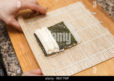 Vorbereitung, Rolling Sushi. Nahaufnahme der Hand von Sushi Meister. Stockfoto