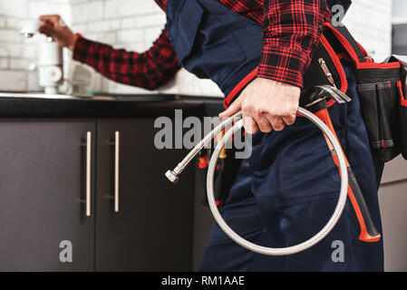 Neue Sanitär. In der Nähe von Meister Überprüfen aller Dinge in der Küche vor den Wasserhahn. 7/8-Foto Stockfoto