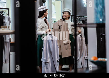 Junge Dunkelhaarige asiatischen hübsche Frau in trendiger headwear Suche zufrieden Stockfoto