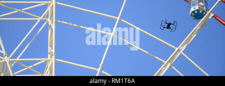 Drone mit photocamera aus Land nehmen und Fliegen für Foto Vorderseite von Riesenrad nehmen Stockfoto