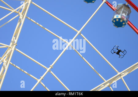 Drone mit photocamera aus Land nehmen und Fliegen für Foto Vorderseite von Riesenrad nehmen Stockfoto