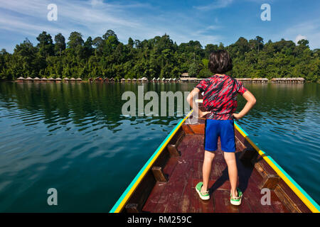 Ein longboat Ansätze eines der 22 schwimmende Bungalows auf CHEOW LAN LAKE in Khao Sok Nationalpark - THAILAND Stockfoto