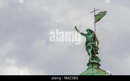 Christus der Erlöser mit heiligen Kreuz und Fahne unter den Wolken. Bronzestatue an der Spitze von St. Simeon Kirche in Venedig, im 18. Jahrhundert errichtet (mit c Stockfoto