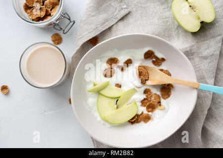 Gesundes Frühstück Multigrain Flakes mit Apple, griechischem Joghurt und hafermilch Draufsicht Stockfoto