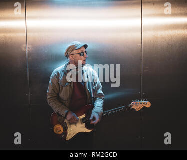 Männliche busker Gitarre spielen in blau Neon beleuchtete Unterführung Fort William schottischen Highlands Schottland Stockfoto