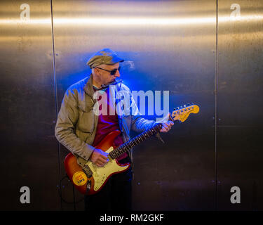 Männliche busker Gitarre spielen in blau Neon beleuchtete Unterführung Fort William schottischen Highlands Schottland Stockfoto
