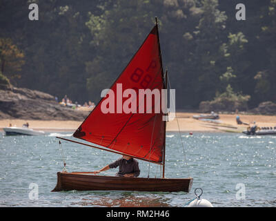 Das kleine Boot mit einem roten Segeln genießen der Salcombe Mündung. Stockfoto