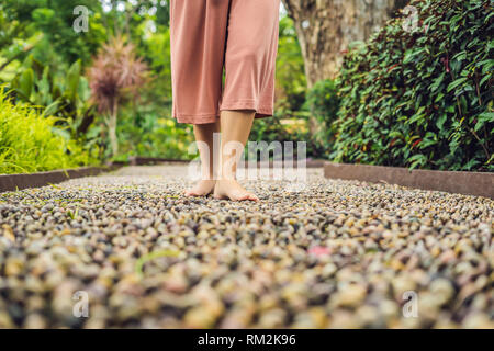 Frau gehen auf eine strukturierte, mit Kopfstein Pflaster, Reflexzonenmassage. Pebble Stones auf dem Bürgersteig für Fußreflexzonenmassage Stockfoto