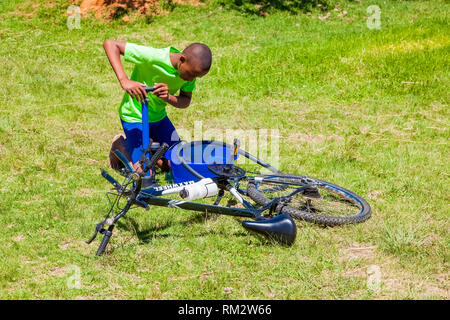 Harrismith, Südafrika - 18. Oktober 2012: Afrikanische Kinder zur Festsetzung einer Reifenpanne auf dem Fahrrad Stockfoto