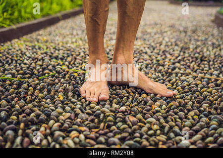 Menschen gehen auf eine strukturierte, mit Kopfstein Pflaster, Reflexzonenmassage. Pebble Stones auf dem Bürgersteig für Fußreflexzonenmassage Stockfoto