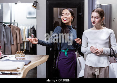 Brunette schöne asiatische Frau in einem Marine Polokragen und ihr Freund guten Gefühl Stockfoto