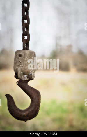 Eine Alte verrostete Kettenzug hängt von der rafter von einem verlassenen Gebäude in ländlichen Alabama. Stockfoto