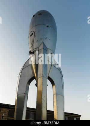 Eine Niedrigwinkelaufnahme der Rocketship-Skulptur vor dem Science Building an der University of Wyoming. Die Skulptur besteht aus genietetem Metall und hat ein Retro-futuristisches Design. Stockfoto