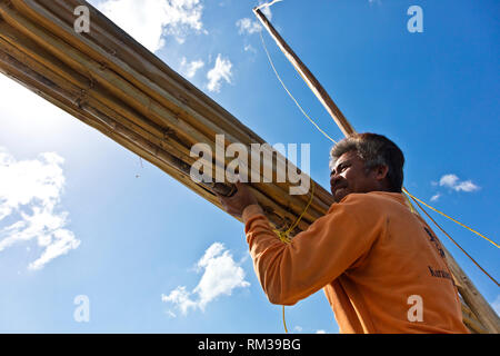 Die MOKEN Mann kann seine Segel auf seinem traditionellen Boot nach KHO RA Insel in der Andamanensee - THAILAND Stockfoto