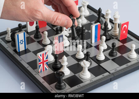 Der Politikerin aus der Hand bewegt sich eine Schachfigur. Konzeptionelle Foto von einem politischen Spiel und Strategie. Stockfoto