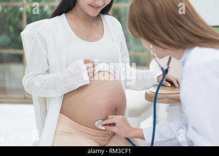 Arzt mit Hand und Stethoskop weiß Prüfung der schwangeren Frau in der Klinik, medizinische Prüfung Konzept. Stockfoto