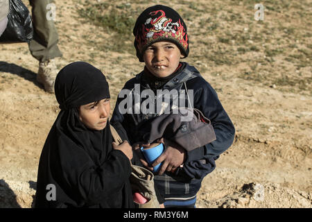 Deir Ezzor, Syrien. 12 Feb, 2019. Kinder gesehen warten auf ihre Familie als Zivilisten der islamische Staat fliehen - statt Dorf Baghouz im östlichen syrischen Provinz von Deir Ezzor. Mehr als 1.500 Menschen haben im vergangenen pocket Islamischen Staat im östlichen Syrien in den letzten 48 Stunden Links zu fliehen, die Schlacht zwischen den Kämpfern der syrischen Demokratischen Kräfte (SDF), einer von den USA unterstützten Kurdischen-Gruppe führte, und der Islamischen Staat. Credit: Aboud Hamam/dpa/Alamy leben Nachrichten Stockfoto