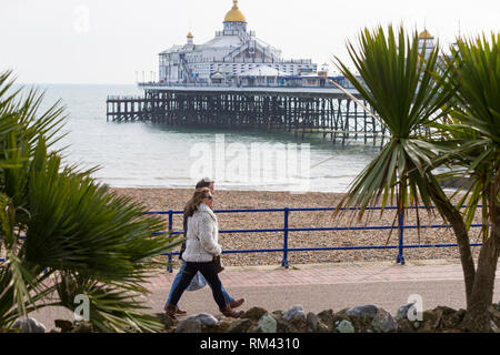 Eastbourne, East Sussex, UK. 13 Feb, 2019. UK Wetter: sonnig Wetter in Eastbourne heute mit Höhen von 10°C. Ein Paar an der Eastbourne Pier an einem hellen und sonnigen Wintertag. © Paul Lawrenson 2019, Foto: Paul Lawrenson/Alamy leben Nachrichten Stockfoto