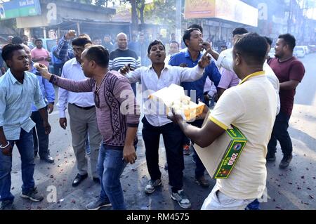 Guwahati, Assam, Indien. 13 Feb, 2019. Aktivisten von Assam Jatiyatabadi Yuba Chatra Parishad (AJYCP) süßen Speisen verteilen und Feuer verbrennen - Cracker, wie sie feiern, nachdem die Bürgerschaft Änderung Rechnung nicht in die Rajya Sabha weitergegeben werden konnten, in Guwahati, Assam am Mittwoch, 13. Februar 2019. Credit: Hafiz Ahmed/Alamy leben Nachrichten Stockfoto