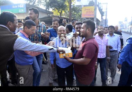 Guwahati, Assam, Indien. 13 Feb, 2019. Aktivisten von Assam Jatiyatabadi Yuba Chatra Parishad (AJYCP) süßen Speisen verteilen und Feuer verbrennen - Cracker, wie sie feiern, nachdem die Bürgerschaft Änderung Rechnung nicht in die Rajya Sabha weitergegeben werden konnten, in Guwahati, Assam am Mittwoch, 13. Februar 2019. Credit: Hafiz Ahmed/Alamy leben Nachrichten Stockfoto