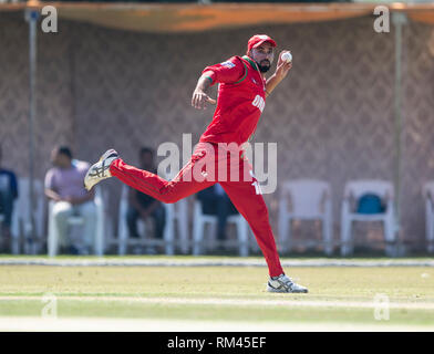 Muscat, Oman. 13 Feb, 2019. Bild zeigt: Große fielding von Oman Bilal Khan, als Irland nehmen auf Oman am ersten Tag des Oman viereckigen Serie. Credit: Ian Jacobs/Alamy leben Nachrichten Stockfoto