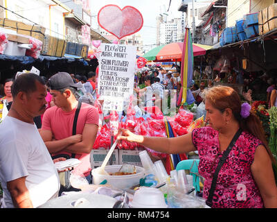 4. Mai 2012, Manila, Philippinen - eine Frau essen Anbieter gesehen Ihr Kunde während der Valentinstag Vorbereitungen auf einem Markt in Manila. (Bild: © Josefiel Rivera/SOPA Bilder über ZUMA Draht) Stockfoto