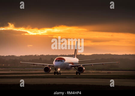 Flugzeug gehören zu Easyjet wartet an der Start- und Landebahn am Flughafen Gatwick in Großbritannien, in der Dämmerung. Stockfoto