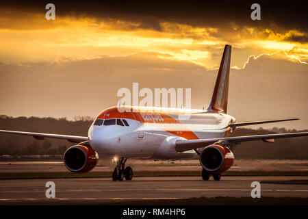 Flugzeug gehören zu Easyjet wartet an der Start- und Landebahn am Flughafen Gatwick in Großbritannien, in der Dämmerung. Stockfoto