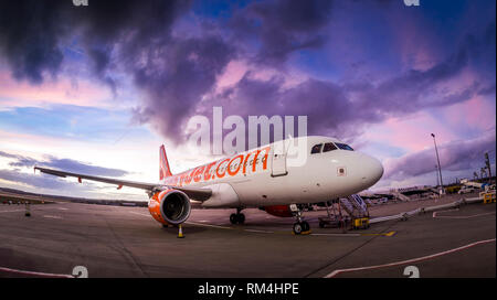 Easyjet Flugzeug warten auf dem Vorfeld des Flughafen Gatwick in Großbritannien, in der Dämmerung. Stockfoto