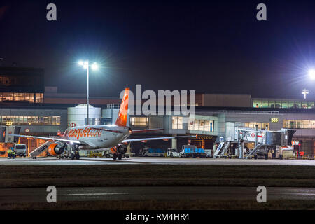 Easyjet Flugzeug warten auf dem Vorfeld des Flughafen Gatwick in Großbritannien, in der Dämmerung. Stockfoto