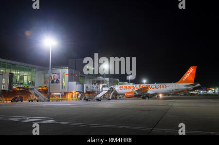 Easyjet Flugzeug warten auf dem Vorfeld des Flughafen Gatwick in Großbritannien, in der Dämmerung. Stockfoto