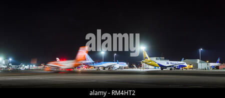 EasyJet-Flugzeug, das sich nachts hinter anderen Flugzeugen bewegt, am Flughafen Gatwick, England. Stockfoto