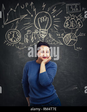 Glücklich lächelnde Frau mit der Hand unter das Kinn, Ziele zu setzen, in eine reiche Phantasie. Business Zeitmanagement und Idee Konzept auf Grau zurück isoliert Stockfoto