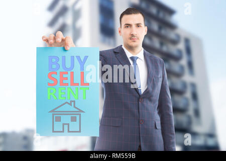 Mann bei der Arbeit als Immobilienmakler präsentiert farbenfrohe Kaufen Verkaufen mieten, Text auf blauem Papier mit Haus Zeichnung Stockfoto