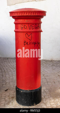 Die traditionellen britischen Stil Rot Postpillar Box, Box Mailbox mit Graffiti gehen vegan Gerne in Lagos Altstadt Portugal geschrieben Stockfoto