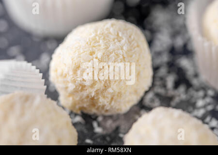 Hausgemachte Süßigkeiten weiße Schokolade und Kokosnuss auf einem dunklen Hintergrund. Set Candy Trüffel Schneeball. Stockfoto