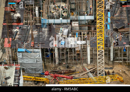 Luftaufnahme eines Gebäudes Baustelle in Fortschritte mit Turm Kran, Gerüst, Form, Materialien, Ausrüstung und Arbeit Mannschaften an Stockfoto